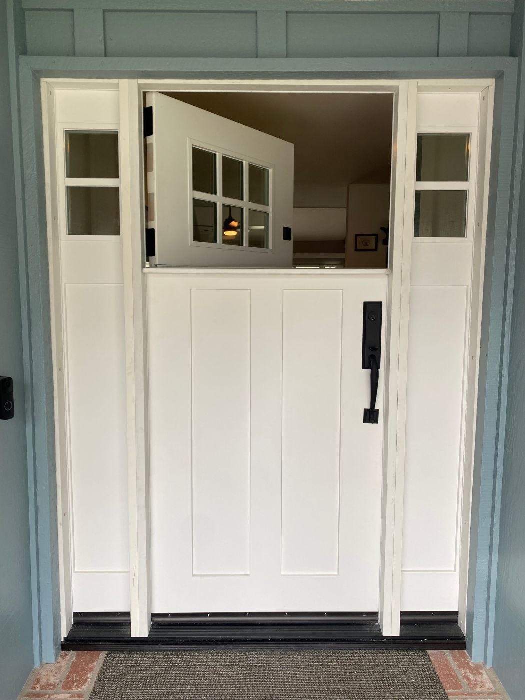 White Dutch door with paneled sidelites on a blue-green craftsman entry