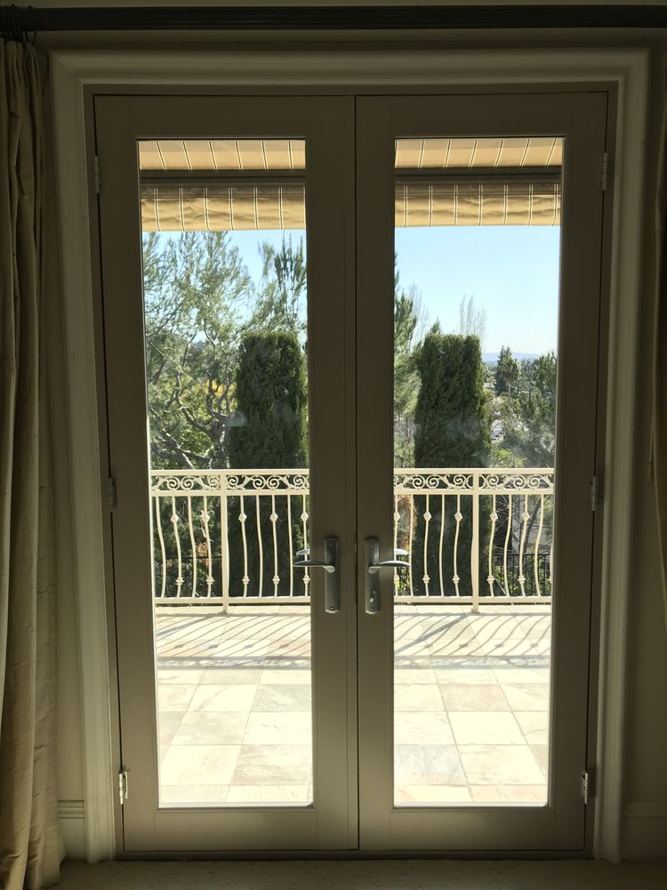 Painted French doors opening onto a balcony with wrought-iron railing