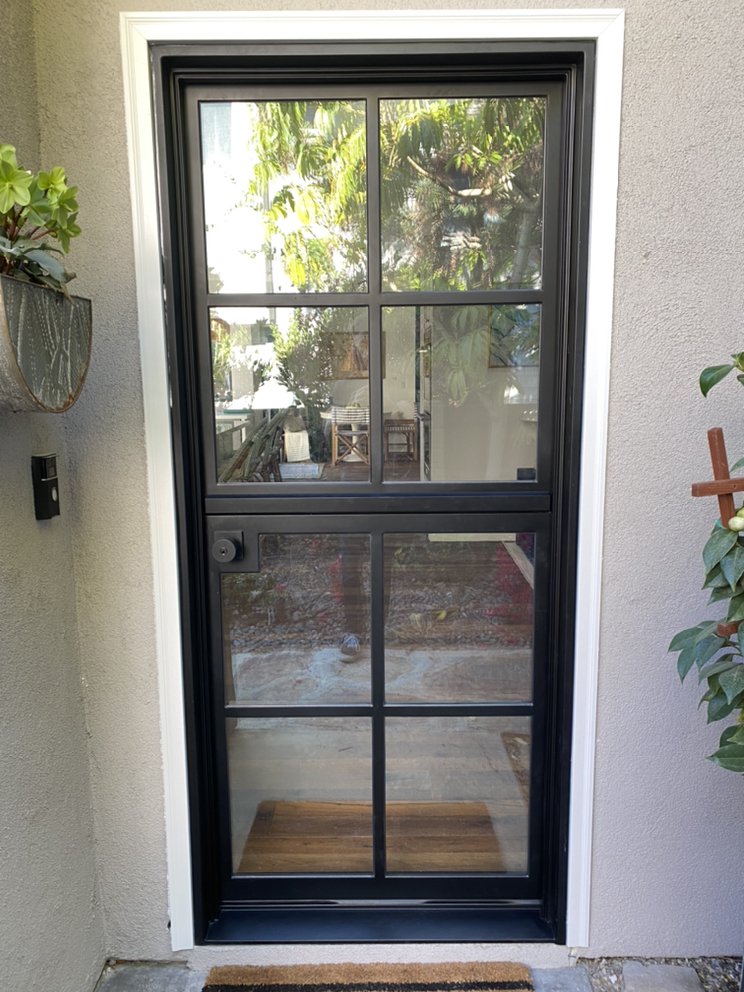 Black steel-framed glass entry door with divided lites