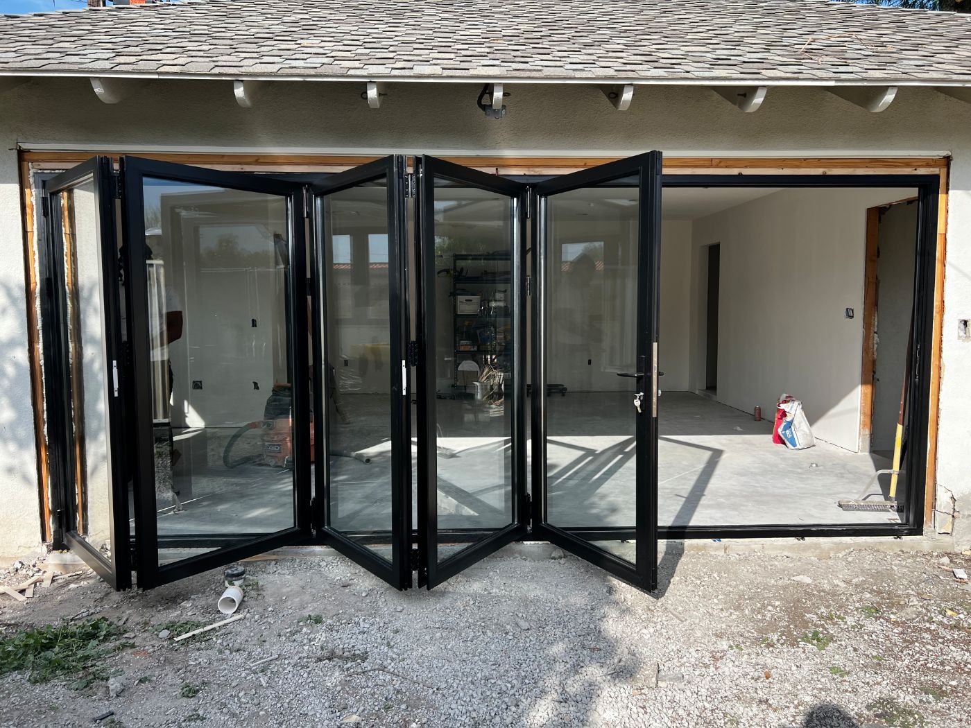 Black aluminum bi-fold glass door wall, partially folded open