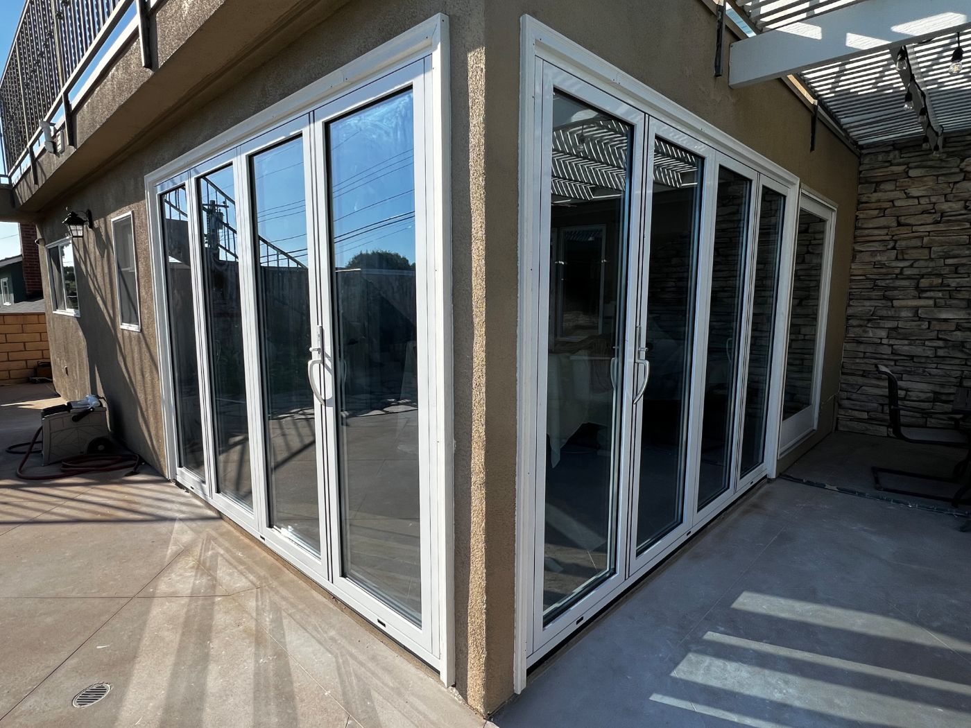 White bi-fold glass doors wrapping an exterior corner of a home