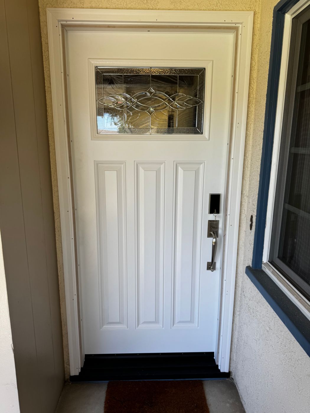 White three-panel entry door with leaded beveled glass, newly trimmed