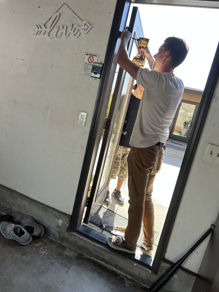 Divine Door Works installer fastening a new glass entry door into its frame