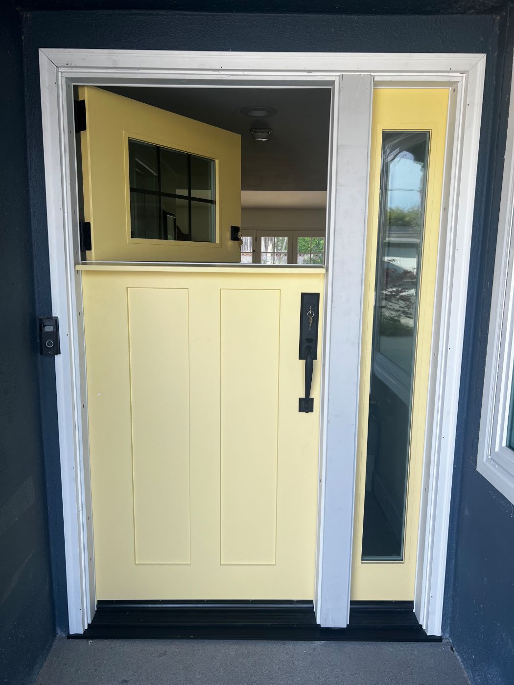 Yellow Dutch door with a single glass sidelite, top half open